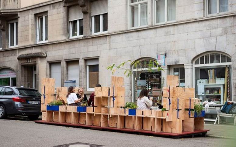 a small green-space on a city street created with plywood.
